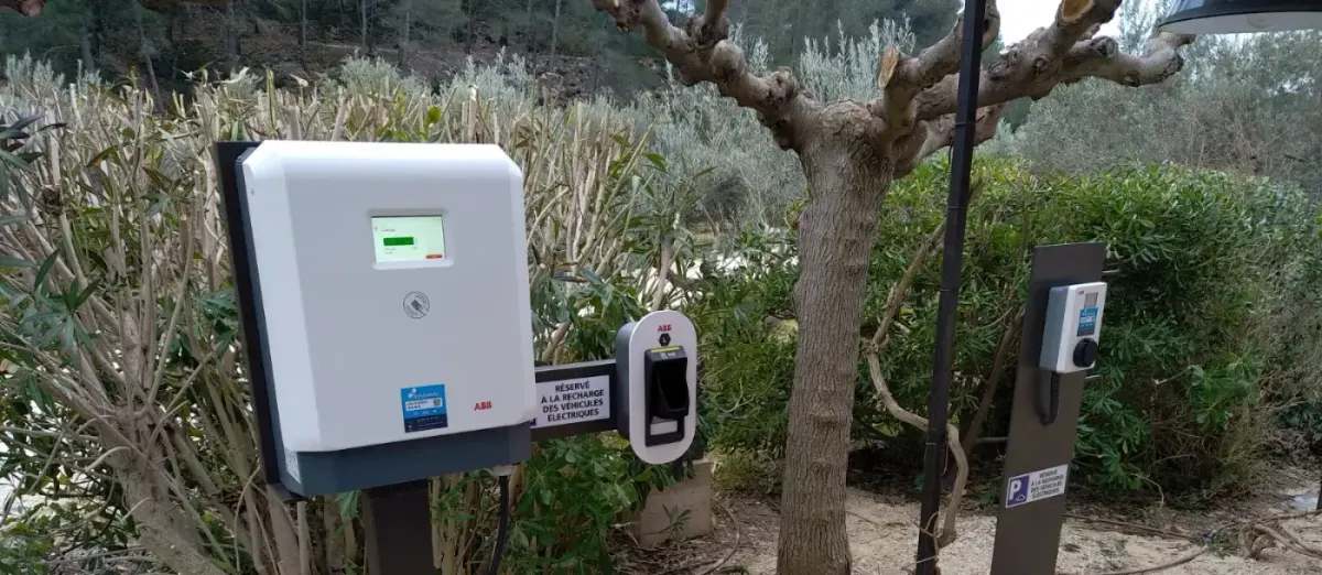 Borne de recharge sur pied installée en extérieur sur un espace paysager