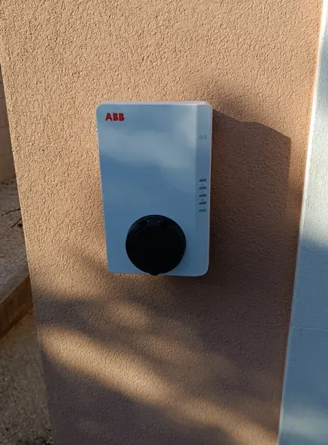 Borne de recharge ABB Terra AC fixée et raccordée sur une façade extérieure
