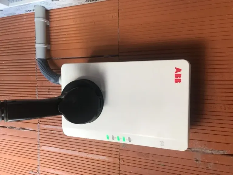Raccordement d'une borne de recharge en apparent sur une façade, câblage soigné et repéré